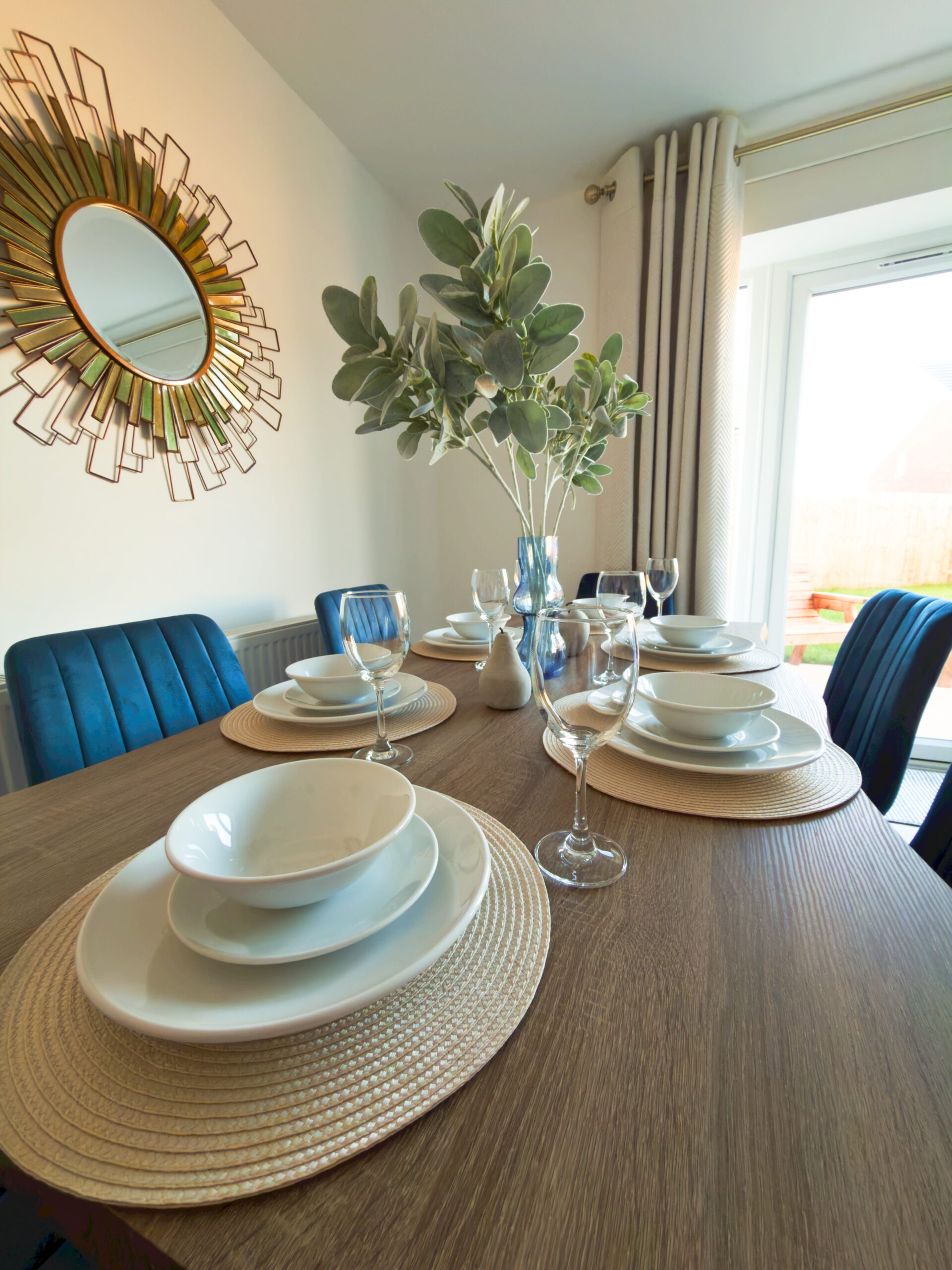 Living Room # (3) Elegant dining table set with white dishes, wine glasses, and blue chairs.