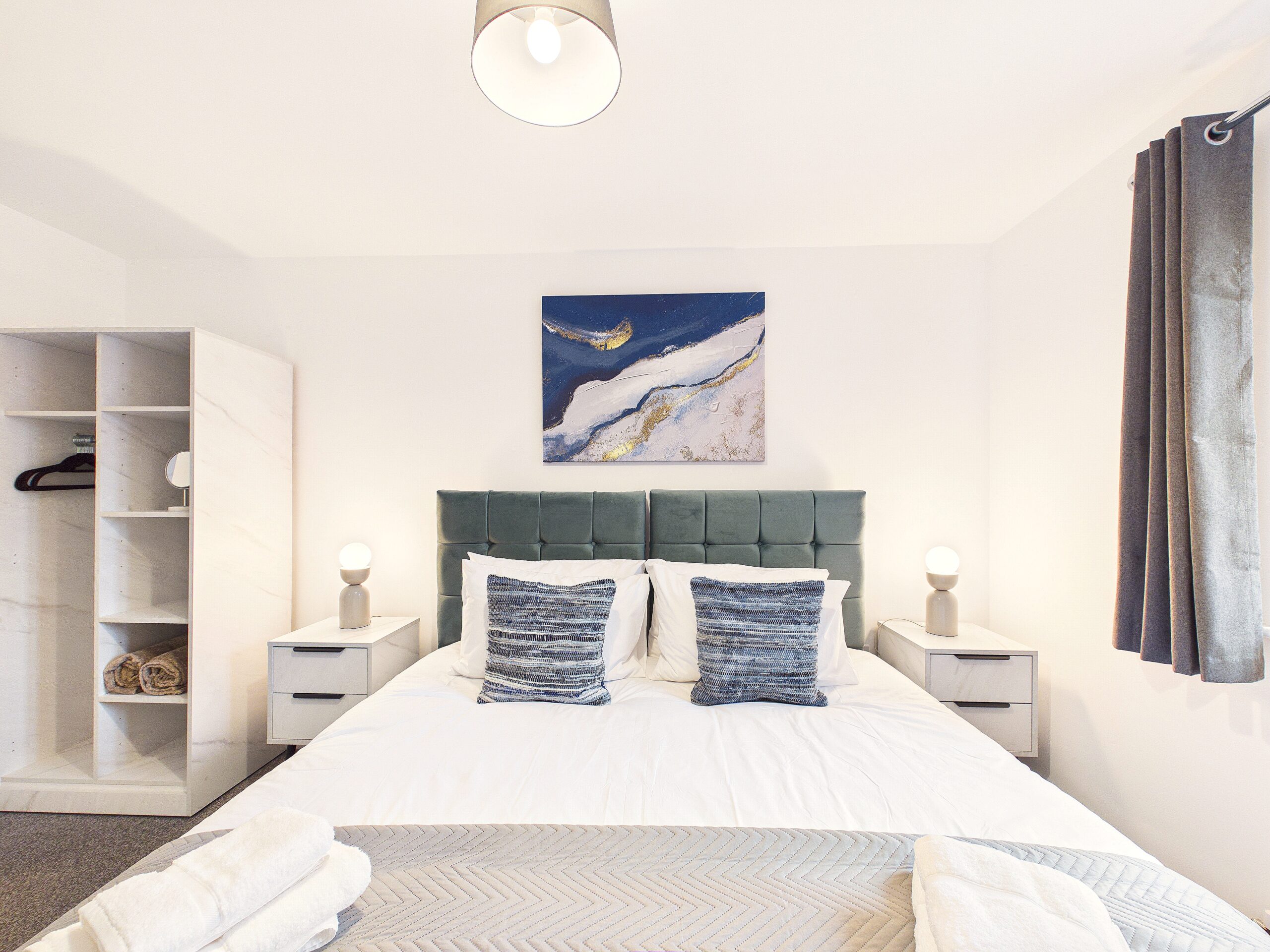 Nightingale - Bedroom 1 (SuperKing) (1) Modern bedroom with teal headboard and abstract wall art.